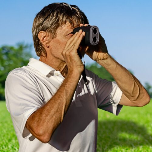 Golfer using a handheld rangefinder on the course